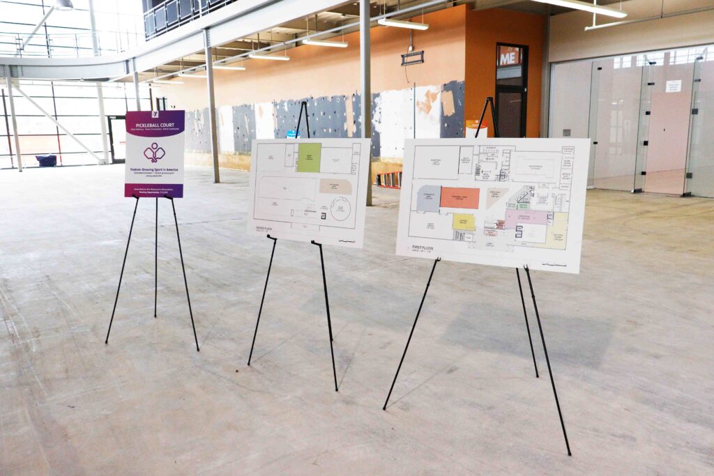 The image shows the Sylvania YMCA's core interior space with maps of the planned building layout as of May 2026.